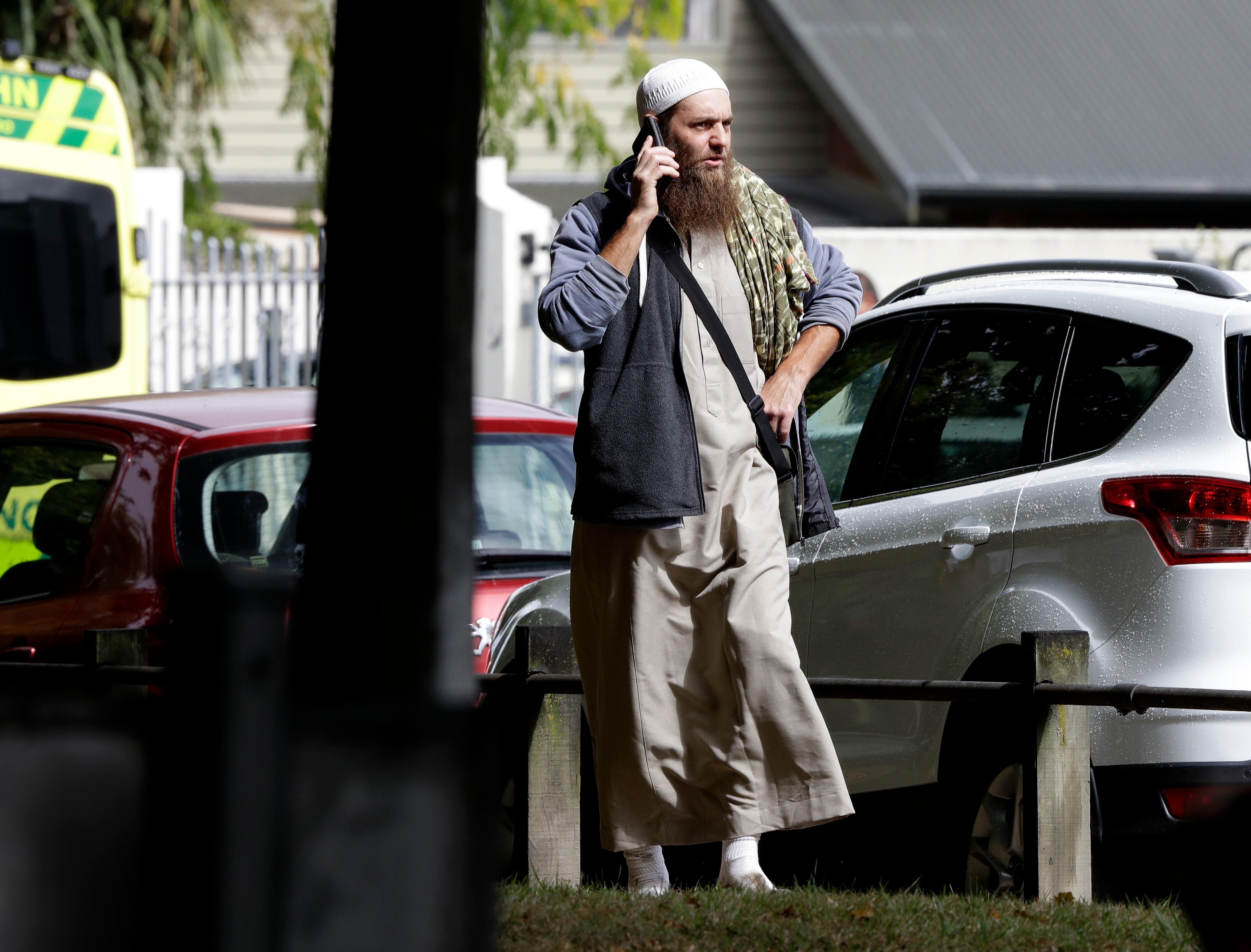 a man talks on his mobile phone across the road from a mosque in